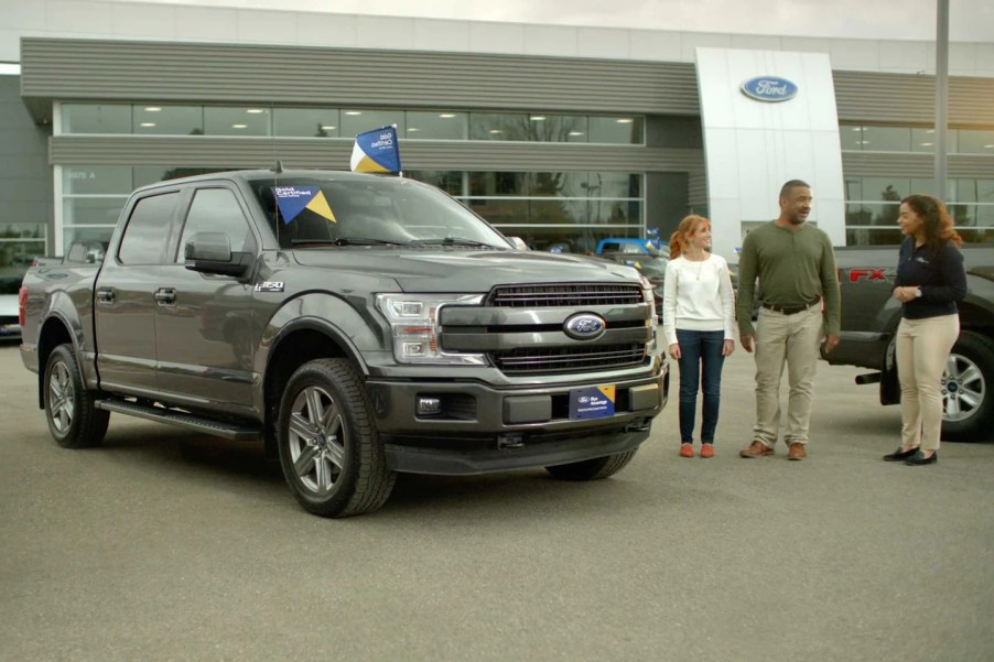 Two people buying a truck at a Ford dealership