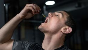 A white male takes CBD oil via a dropper directly into his mouth. Marijuana products are used by some truck drivers.