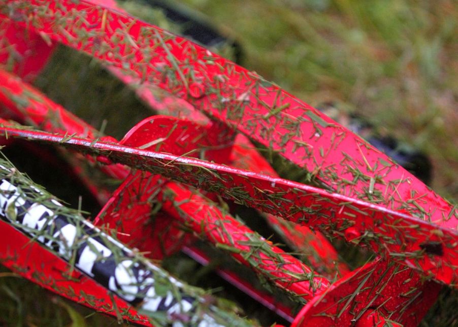 Red Great States reel lawn mower covered in grass clippings