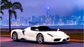 The 1-of-1 Bianco Avus white 2003 Ferrari Enzo in front of a nighttime city skyline