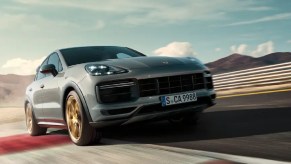 A gray 2022 Porsche Cayenne driving around a track.