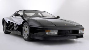 A black 1987 Ferrari Testarossa in a white studio