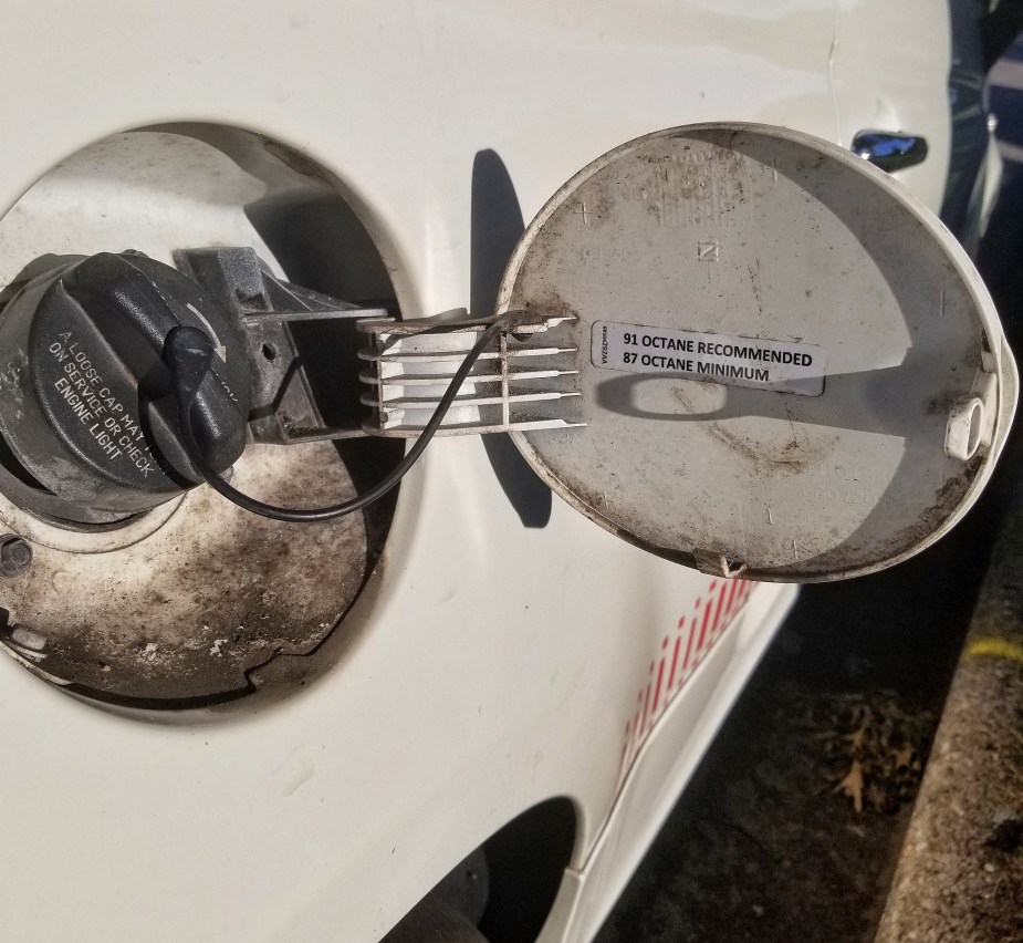 The fuel octane rating sticker on the inside of a white 2013 Fiat 500 Abarth's fuel-filler door