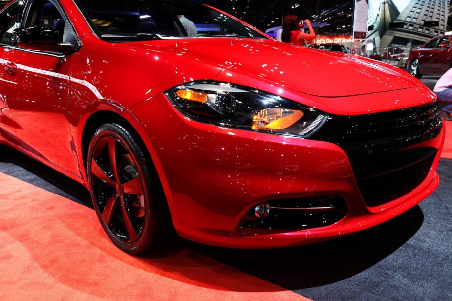 A red 2014 Dodge Dart, known to be among the cheap cars, parked indoors.