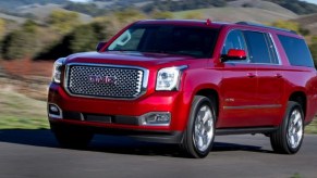 A red 2017 GMC Yukon driving outside.