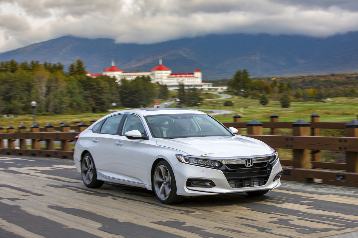 A white 2018 Subaru Legacy midsize sedan driving along a road