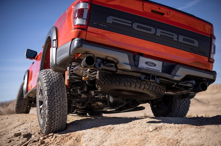 A red 2022 Ford F-150 Raptor traveling through a desert like area.