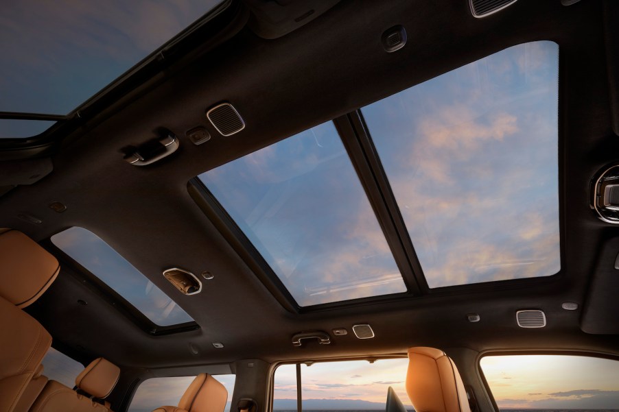 Pink clouds visible through the sunroof of a Jeep Grand Wagoneer luxury SUV.