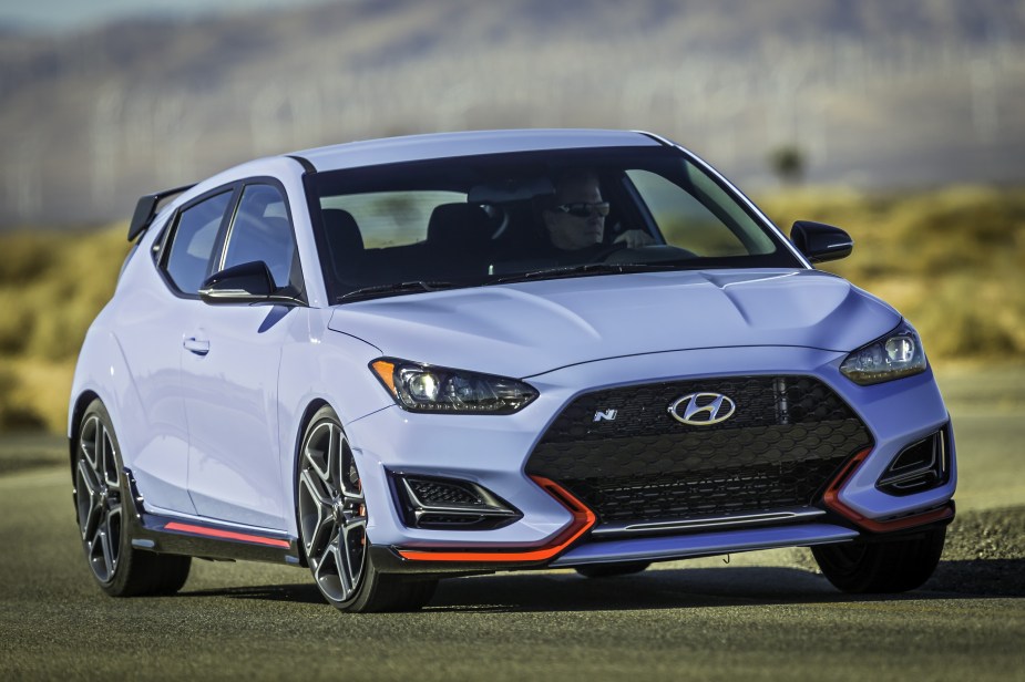 A light-blue 2022 Hyundai Veloster N cornering on a desert racetrack