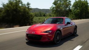 A red 2022 Mazda MX-5 Miata driving down a street