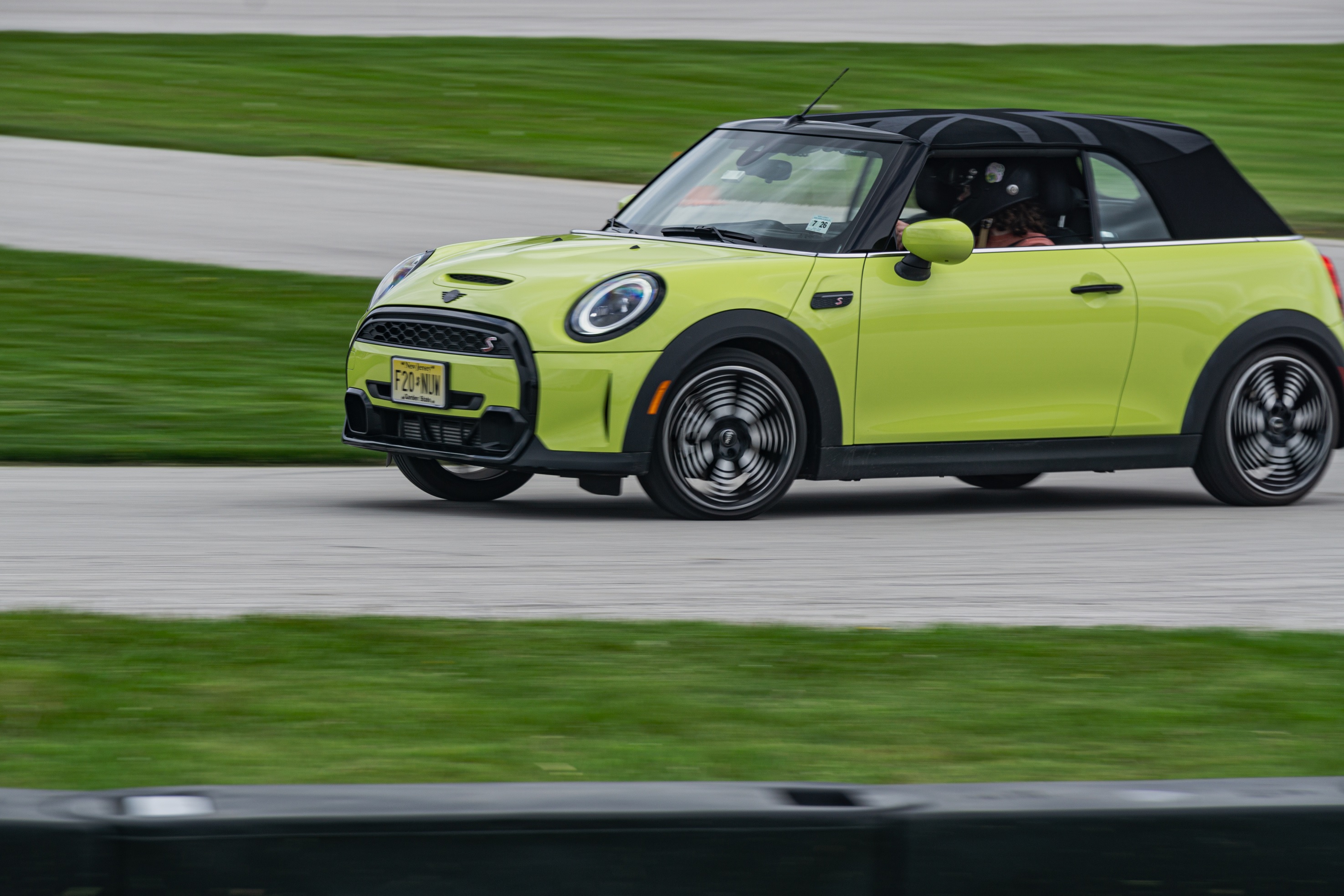 A yellow-green 2022 Mini Cooper S Convertible cornering around Road America's autocross course