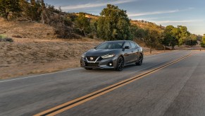 2022 Nissan Maxima driving at speed on a two lane highway in the desert.