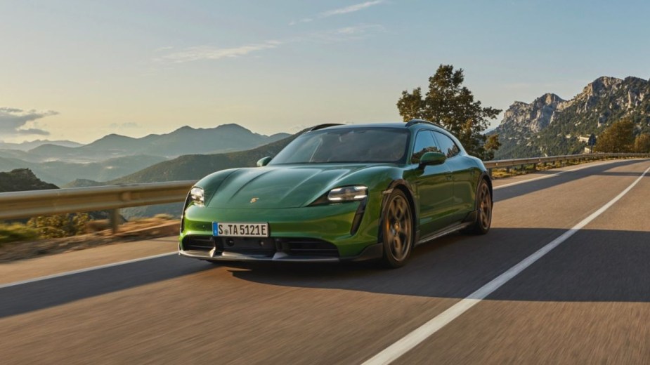 a porsche taycan driving on a cliffside road
