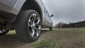 Closeup of the rim of a Ram V8 pickup truck with a train track visible in the background.