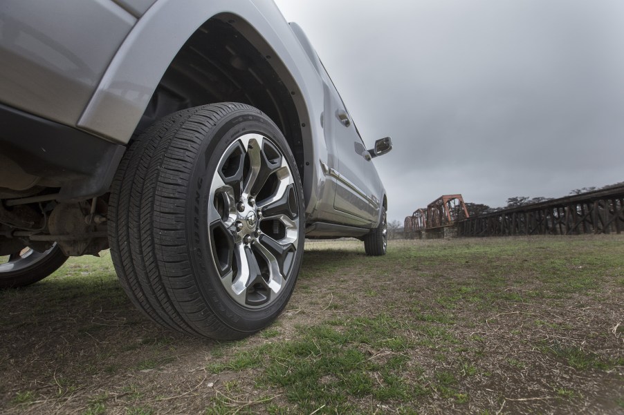 Closeup of the rim of a Ram V8 pickup truck with a train track visible in the background.