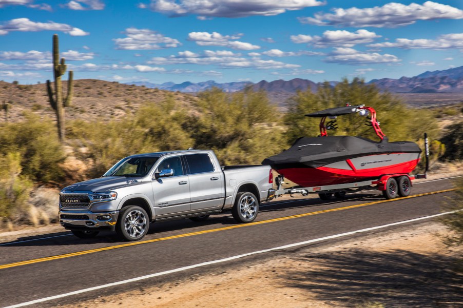 A silver 2022 Ram 1500 towing a boat.