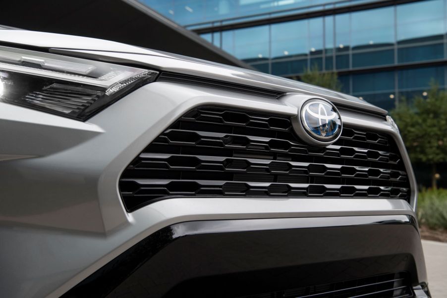 A front photo of the headlights, badging, and grille of a 2022 Toyota RAV4 Hybrid SE compact crossover SUV