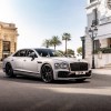 A silver-gray 2023 Bentley Flying Spur S in a European city square