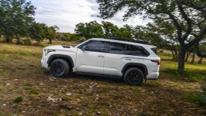 White Toyota Sequoia 4x4 SUV off-roading through the woods.