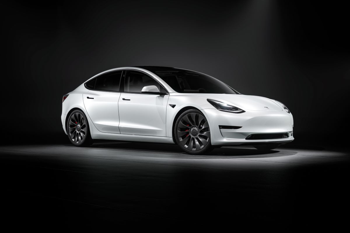 White Tesla Model 3 luxury electric car set against a dark background