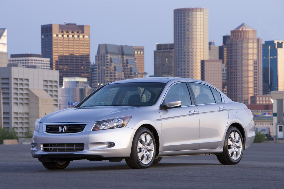 A silver 8th-gen 2008 Honda Accord EX-L V6 parked in front of a city skyline