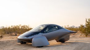 A white Aptera parked in the desert.