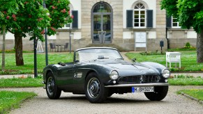 BMW 507 roadster parked in front of large house with gorgeous green grass and trees