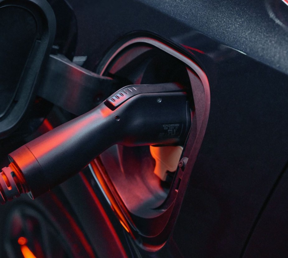 Black 2023 Chevy Bolt EUV, the cheapest electric SUV available, plugged into a charging station