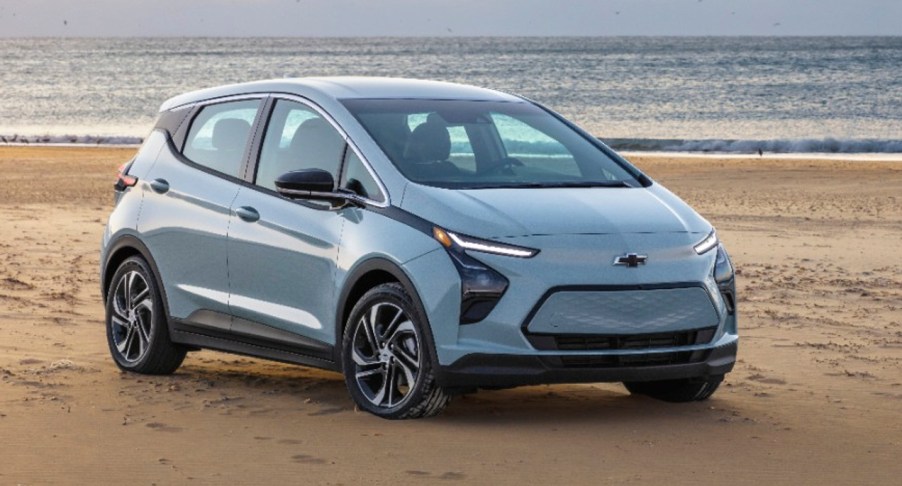 A silver 2023 Chevy Bolt EV electric hatchback is parked on sand.