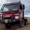 A red EarthCruiser CORE driving off-road