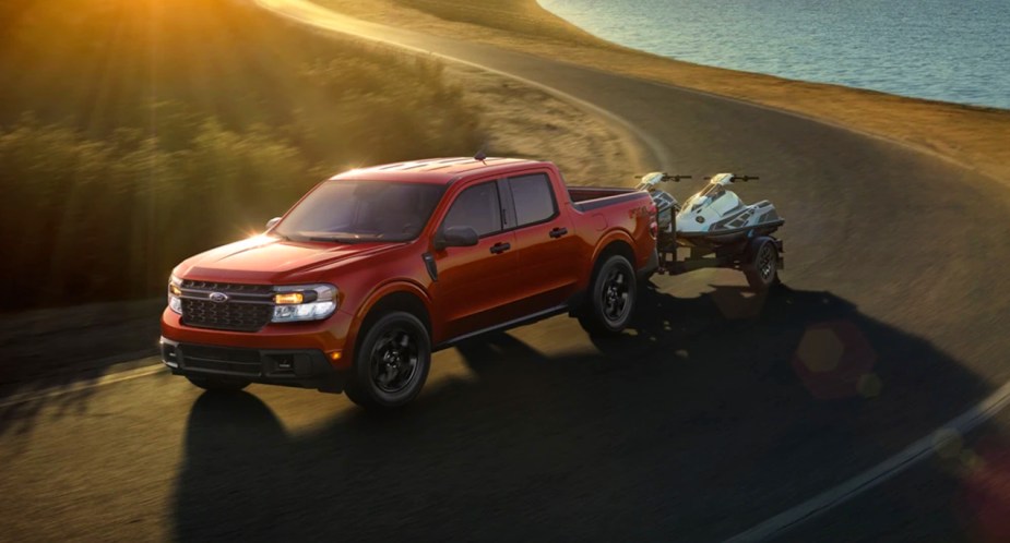 A red Ford Maverick small piickup truck is driving on the road. 