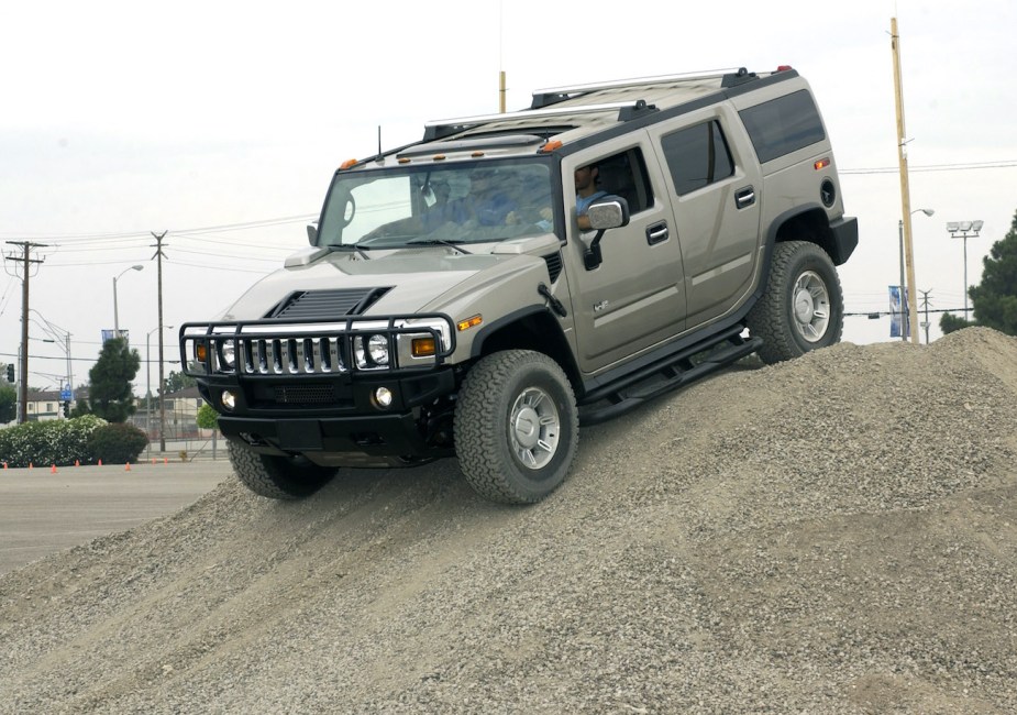 A Hummer H2 drives over a hill.