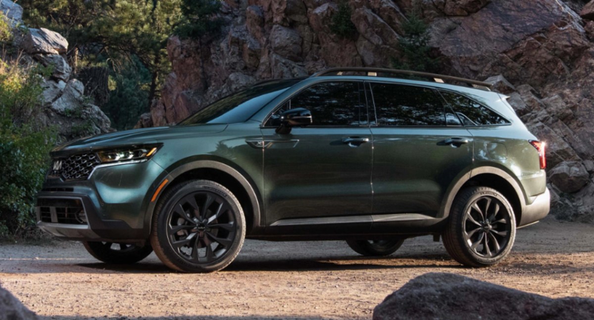 The 2023 Kia Sorento Hybrid in green parked on a dirt road. 