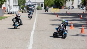 Children on kids motorcycles riding.