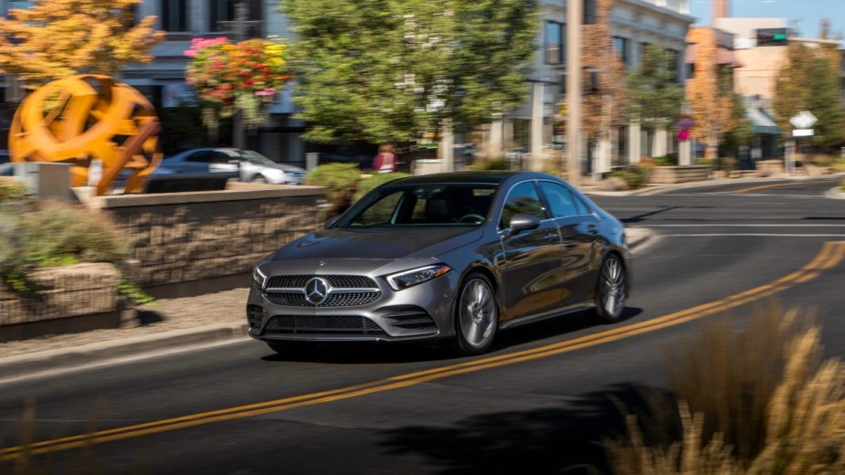 a new mercedes benz a class driving along a city street, a sharp looking compact luxury car