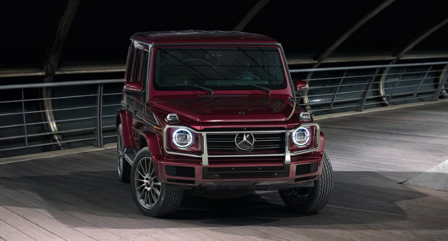 A burgundy Mercedes-Benz G-Class luxury SUV is parked. 