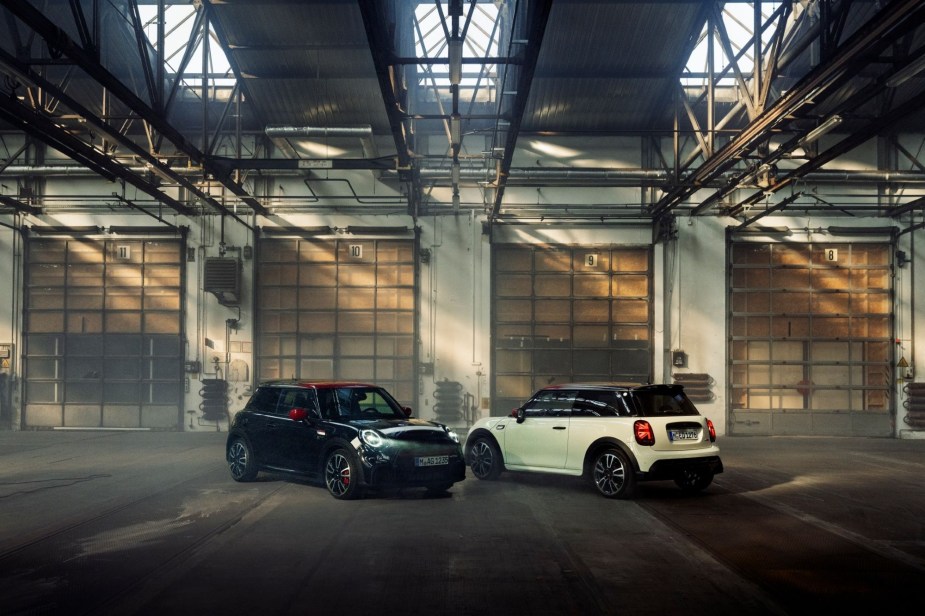 a black and white MINI Cooper in a garage area. 