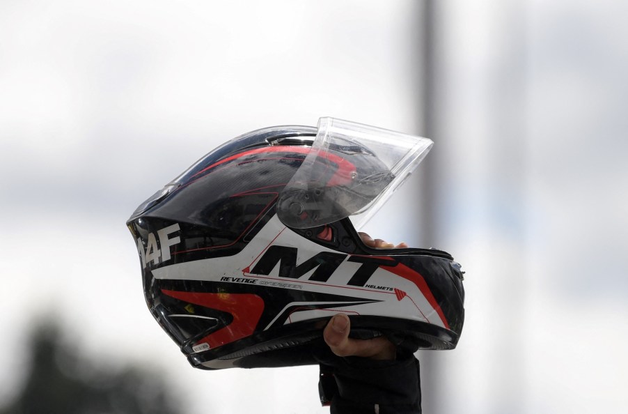 A motorcycle helmet being held in the air.