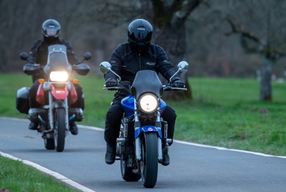 Two motorcycle riders making their way down the highway. 