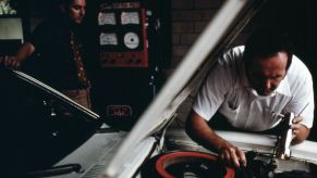 A person working on a car, possibly putting a mechanic lien on the car.