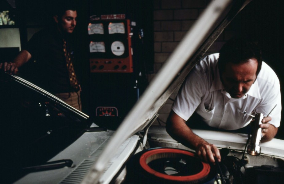 A person working on a car, possibly putting a mechanic lien on the car. 