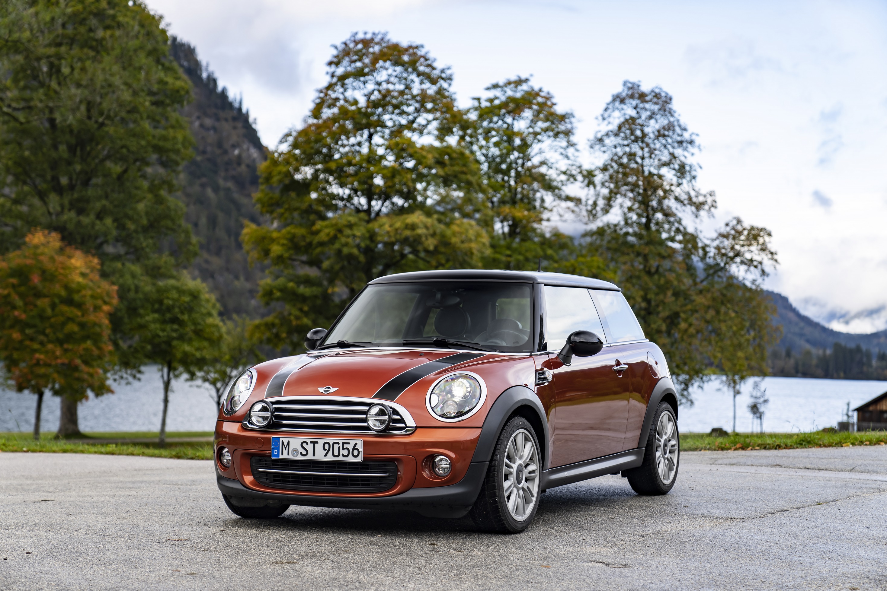 An orange-with-black-stripes post-update R56 Mini Cooper in a mountain parking lot