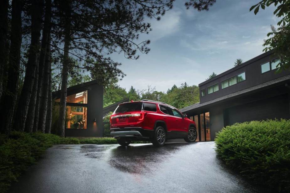 Rear angle view of red 2023 GMC Acadia, highlighting its release date and price