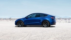 A blue 2022 Tesla Model Y electric SUV is parked.