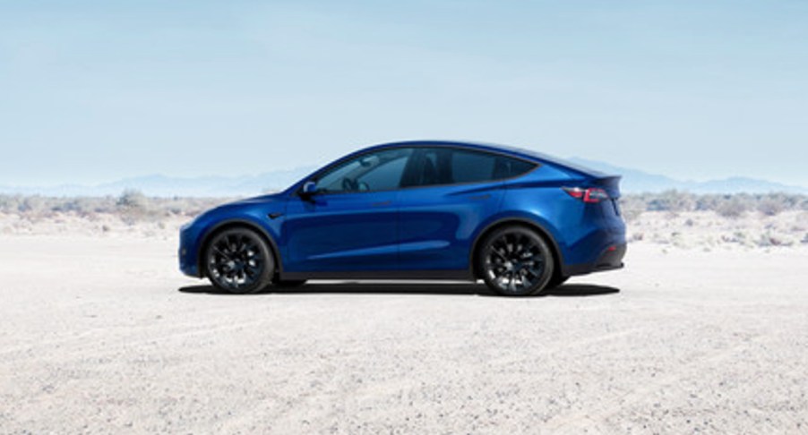 A blue 2022 Tesla Model Y electric SUV is parked.