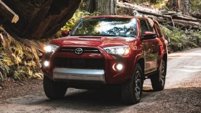 A red 2022 Toyota 4Runner midsize SUV is driving off-road.