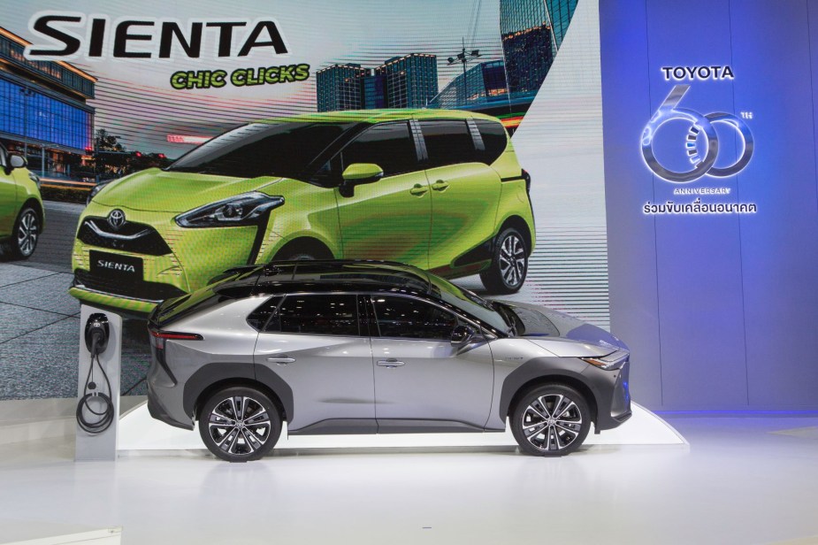 A silver Toyota bZ4X on a white platform indoors.