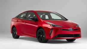 A red Toyota Prius in a white and grey room.