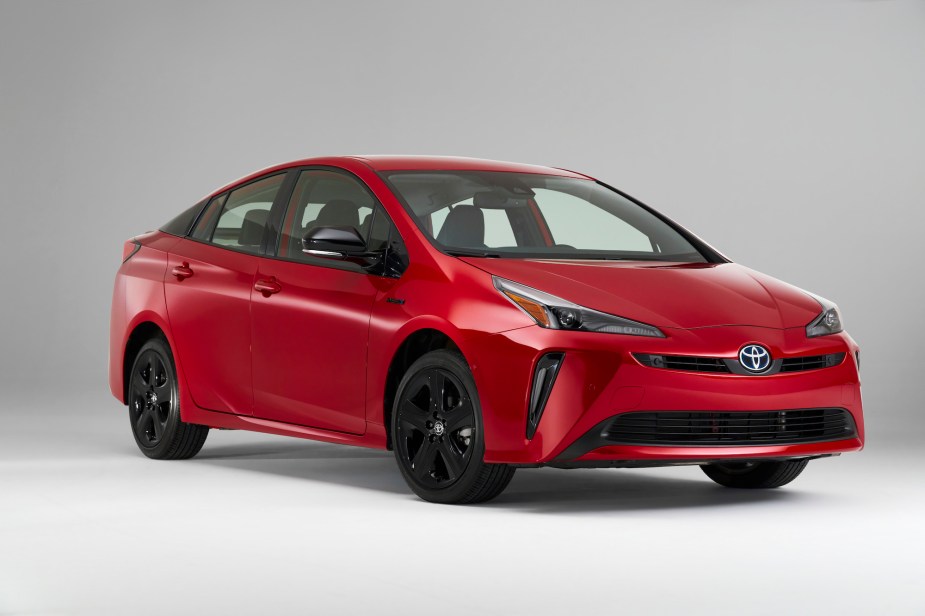 A red Toyota Prius in a white and grey room. 