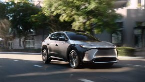 A gray 2023 Toyota bZ4X electric SUV is dirivng on the road.